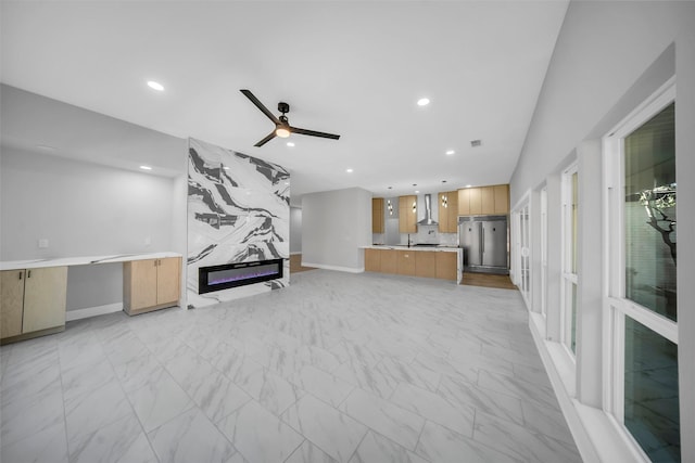 unfurnished living room with ceiling fan and a fireplace