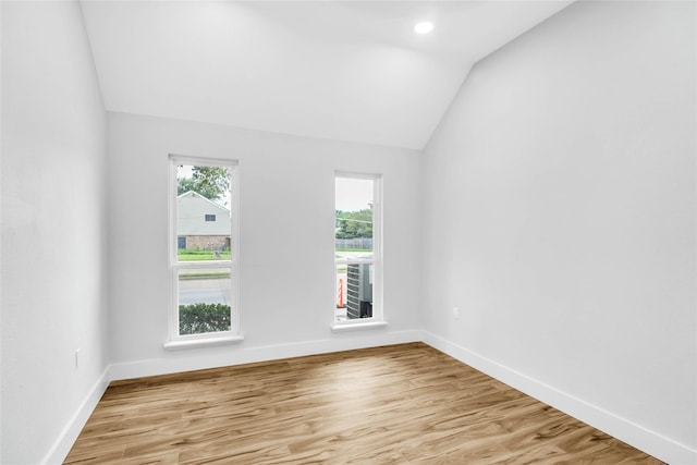 empty room with light wood-type flooring and lofted ceiling