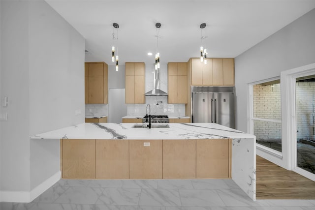 kitchen with light brown cabinets, stainless steel built in fridge, wall chimney exhaust hood, decorative light fixtures, and light stone counters