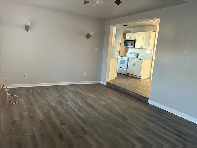 unfurnished living room with ceiling fan and dark wood-type flooring