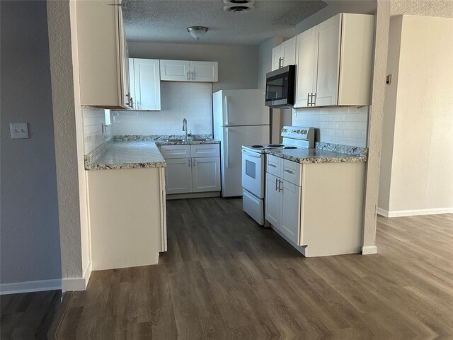 kitchen featuring sink, white appliances, white cabinetry, and decorative backsplash