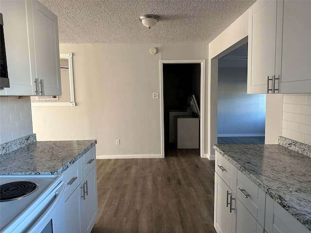 kitchen featuring a textured ceiling, backsplash, white cabinetry, and light stone counters