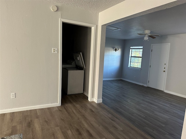 unfurnished living room featuring dark wood-type flooring, a textured ceiling, and ceiling fan