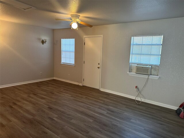 unfurnished room with dark wood-type flooring, plenty of natural light, and cooling unit