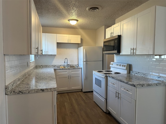 kitchen with white appliances, white cabinetry, decorative backsplash, sink, and dark hardwood / wood-style flooring