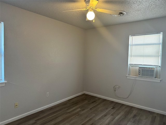 empty room with cooling unit, ceiling fan, dark wood-type flooring, and a textured ceiling