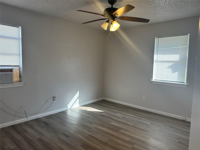 empty room with ceiling fan, dark wood-type flooring, a textured ceiling, and cooling unit