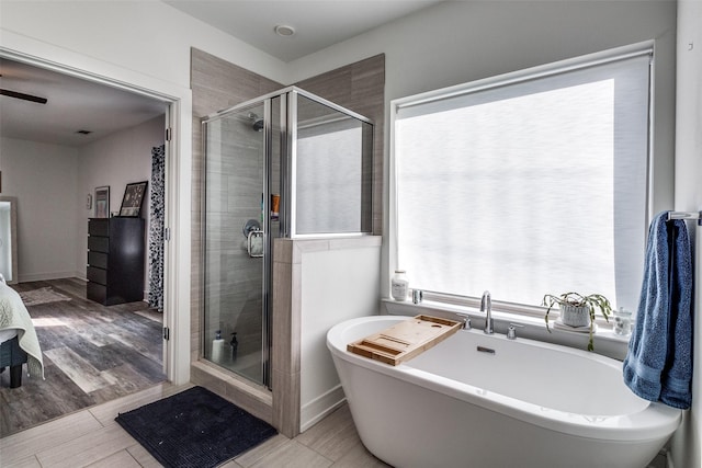 bathroom with shower with separate bathtub and wood-type flooring