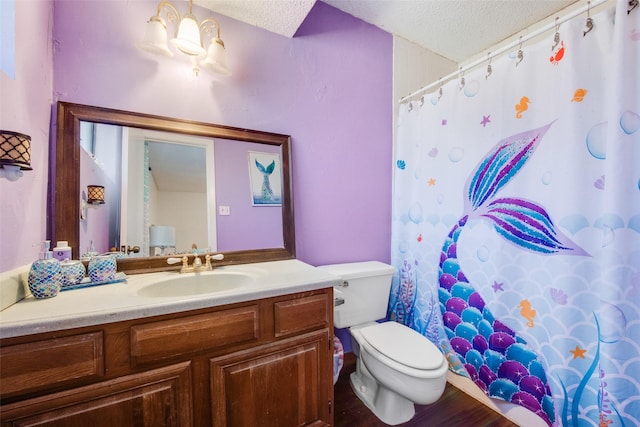 bathroom with a textured ceiling, toilet, and vanity