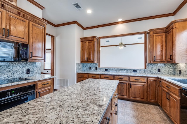 kitchen featuring light stone counters, visible vents, brown cabinets, and black appliances