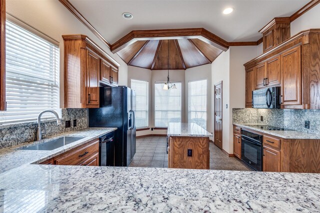 kitchen with pendant lighting, backsplash, ornamental molding, a kitchen island, and black appliances