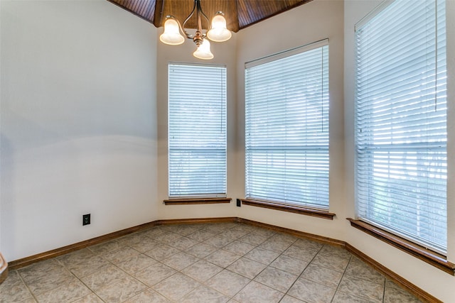 tiled spare room with an inviting chandelier