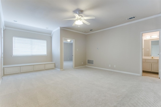 unfurnished bedroom featuring visible vents, light carpet, baseboards, and crown molding