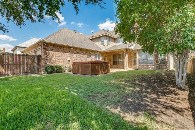 back of house with a yard and a hot tub