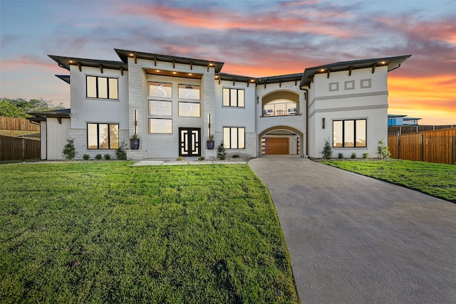 contemporary house featuring a garage and a lawn