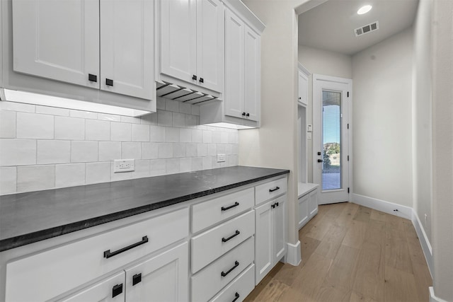 kitchen featuring white cabinetry, light hardwood / wood-style flooring, and decorative backsplash