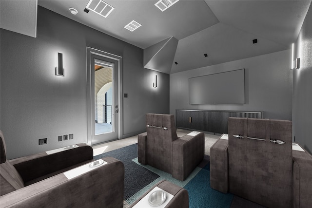 cinema room with vaulted ceiling and carpet floors