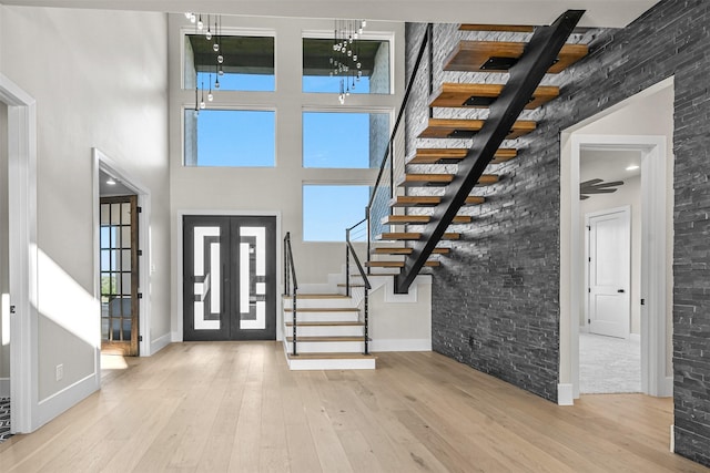 foyer featuring a high ceiling, light hardwood / wood-style flooring, and french doors