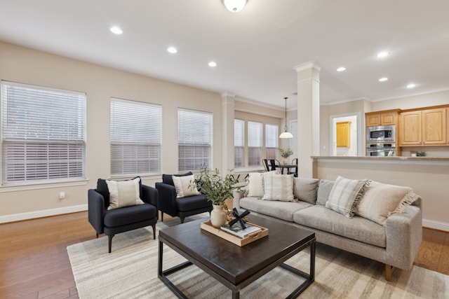 living room with light wood-type flooring and ornate columns