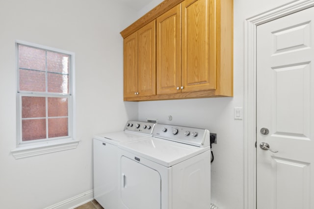 clothes washing area with cabinets, washer and dryer, and plenty of natural light