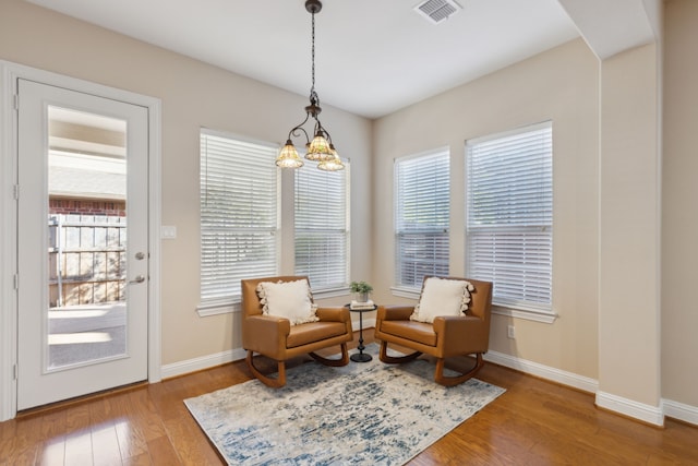 sitting room featuring a notable chandelier and hardwood / wood-style flooring