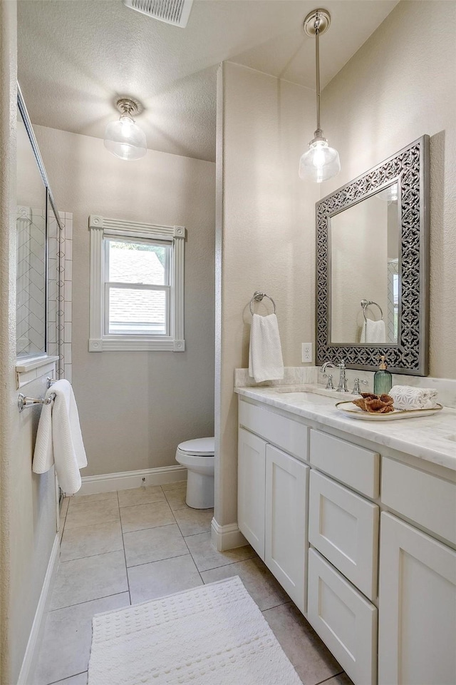 bathroom featuring a textured ceiling, toilet, vanity, and tile patterned flooring