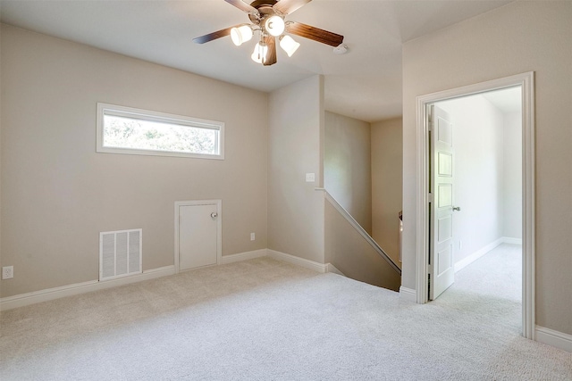 spare room with ceiling fan and light colored carpet