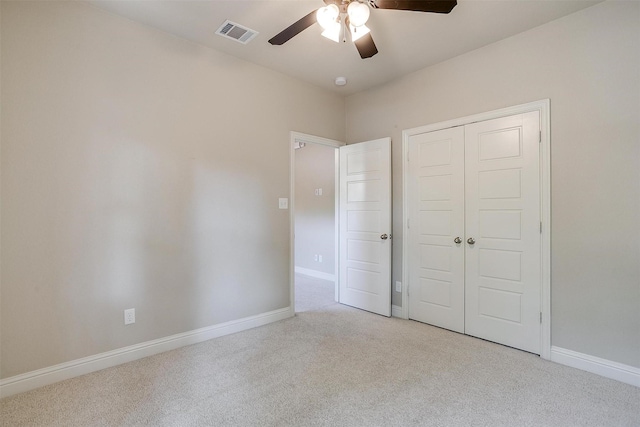 unfurnished bedroom featuring light colored carpet, a closet, and ceiling fan