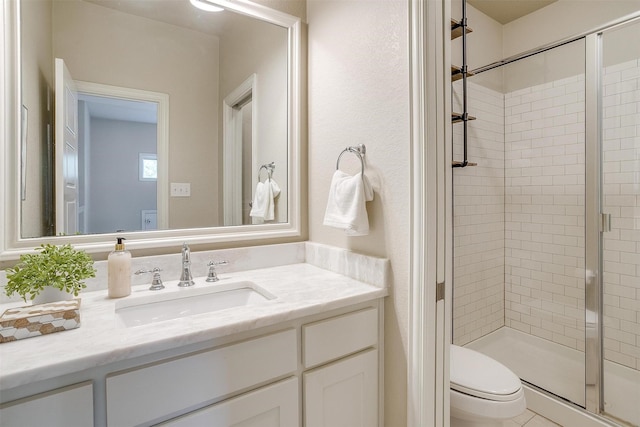 bathroom with toilet, an enclosed shower, and vanity