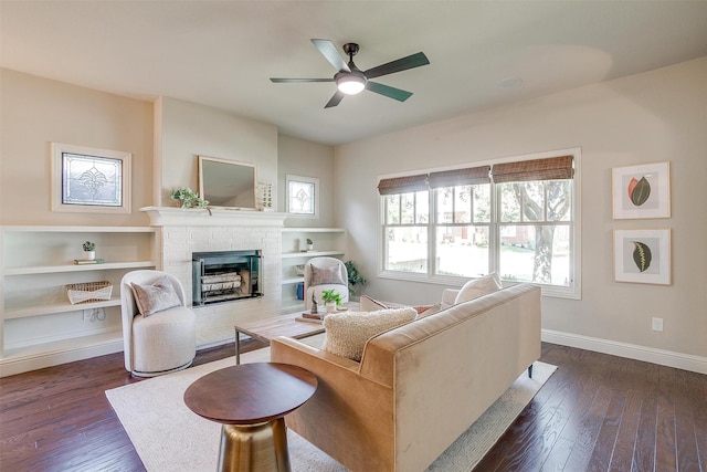 living room with ceiling fan, dark wood-type flooring, and a fireplace