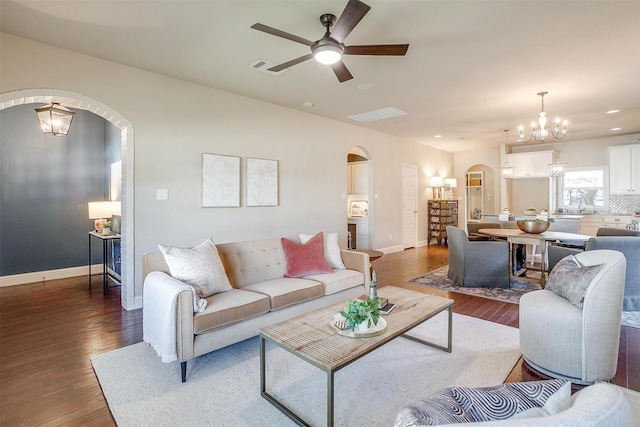 living room featuring ceiling fan with notable chandelier, sink, and dark hardwood / wood-style floors