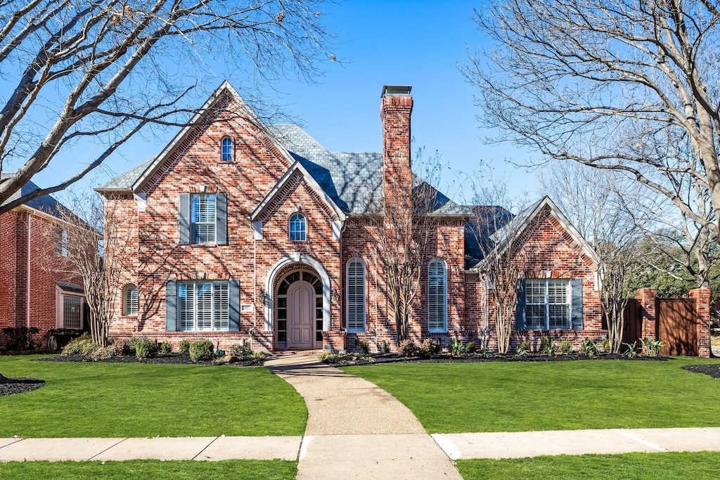 english style home featuring a front yard