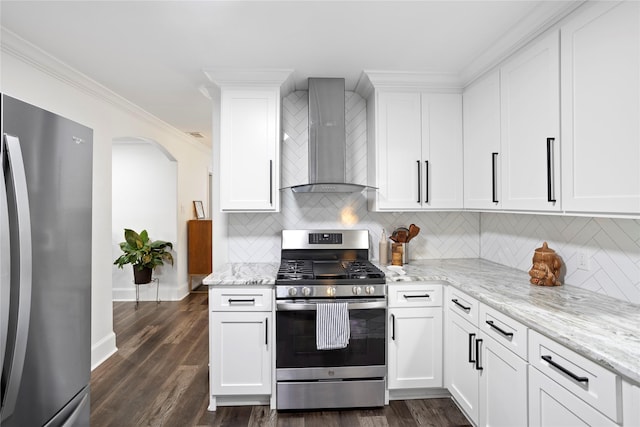 kitchen featuring wall chimney range hood, stainless steel appliances, and white cabinets