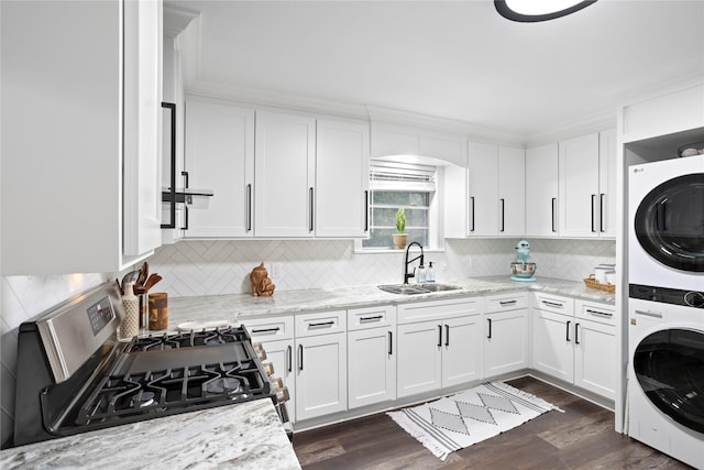 kitchen with white cabinetry, stacked washer and dryer, sink, gas stove, and light stone counters