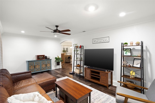 living room with ceiling fan, ornamental molding, and dark wood-type flooring