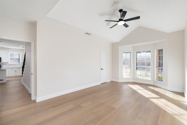 unfurnished room featuring ceiling fan, vaulted ceiling, and light wood-type flooring