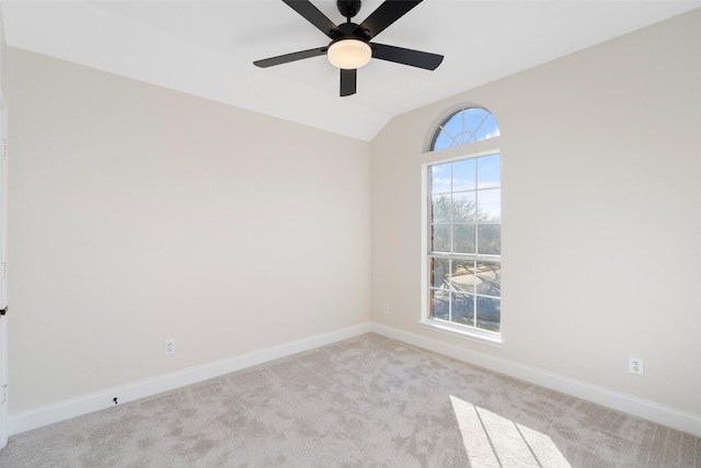 spare room featuring light carpet, lofted ceiling, and ceiling fan