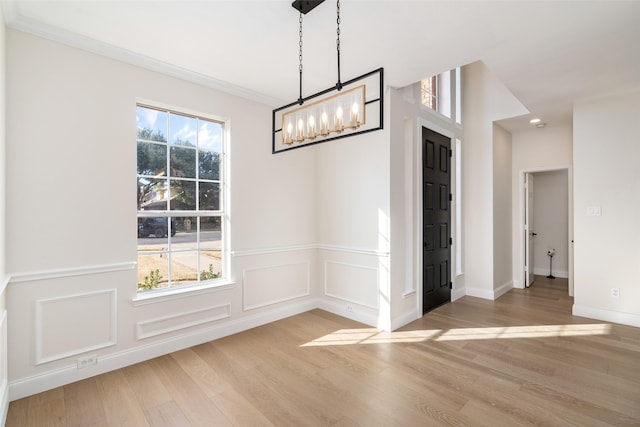 unfurnished dining area featuring ornamental molding, light hardwood / wood-style floors, and a healthy amount of sunlight