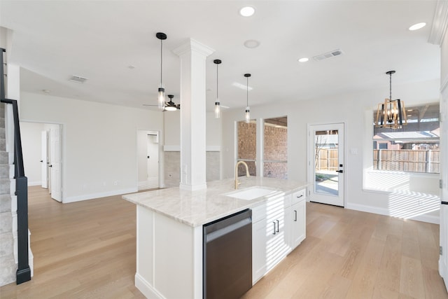 kitchen with pendant lighting, white cabinetry, dishwasher, sink, and an island with sink