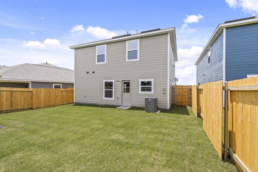 back of house featuring cooling unit and a lawn