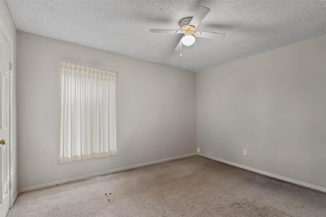 carpeted spare room with a textured ceiling and ceiling fan