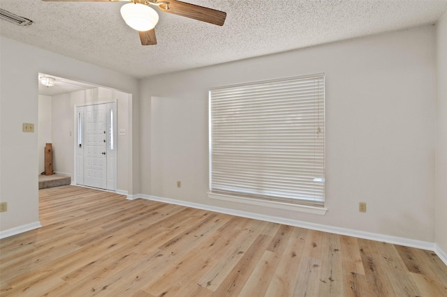 unfurnished room featuring a textured ceiling, light hardwood / wood-style flooring, and ceiling fan