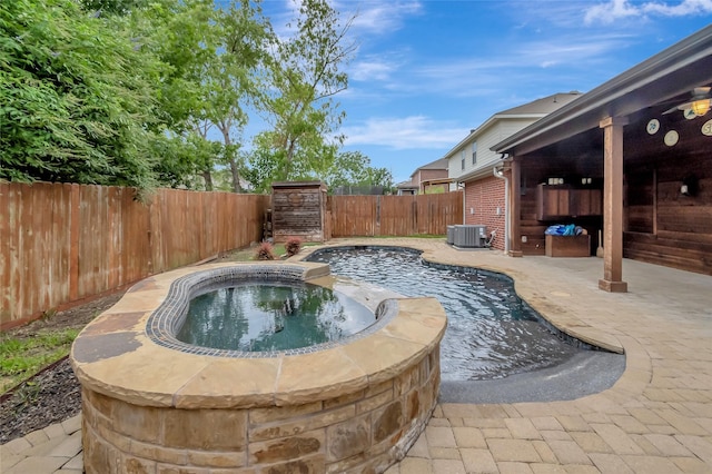 view of pool featuring an in ground hot tub, central AC, and a patio