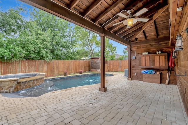 view of pool featuring central AC, pool water feature, an in ground hot tub, ceiling fan, and a patio