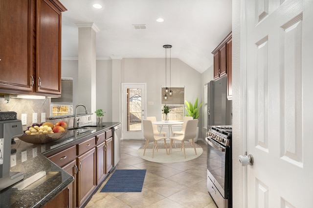 kitchen featuring light tile patterned floors, tasteful backsplash, dark stone counters, stainless steel appliances, and a sink