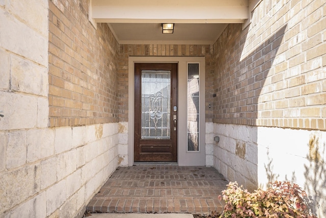 doorway to property featuring brick siding