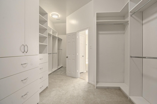 walk in closet featuring light carpet