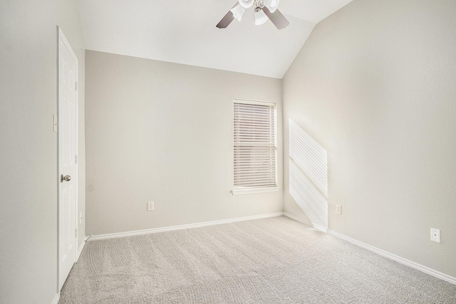 empty room with light carpet, baseboards, vaulted ceiling, and a ceiling fan