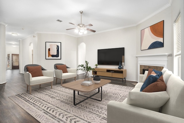 living room with arched walkways, a tile fireplace, wood finished floors, and visible vents