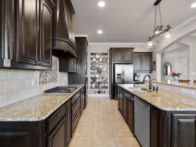 kitchen with sink, dark brown cabinets, hanging light fixtures, custom range hood, and stainless steel appliances